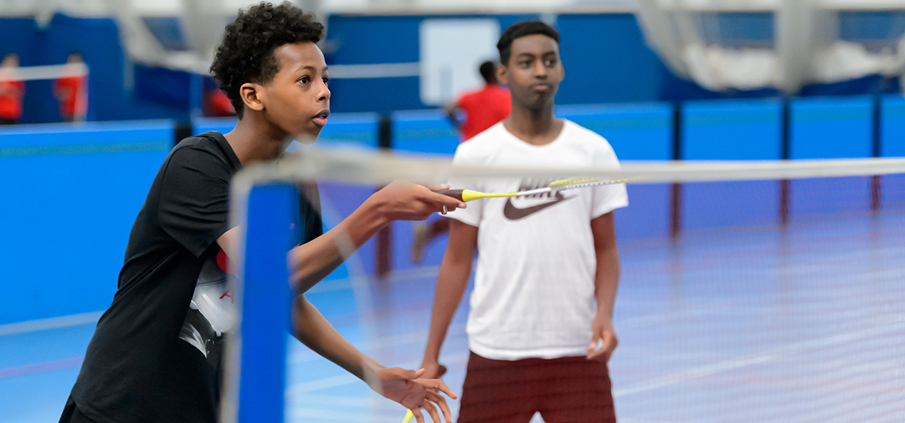 Two boys play badminton in a school PE lesson