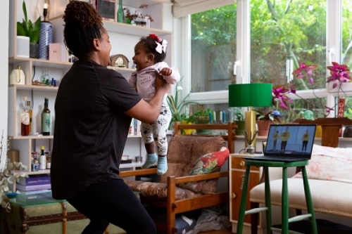 A mum does an exercise class in her living room, with her baby