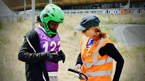 A volunteer speaks to a teenage BMX rider