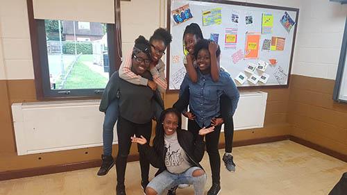 A group of children at the YMCA Sutton Coldfield project pose for a photo, two of whom are giving a piggy back to others