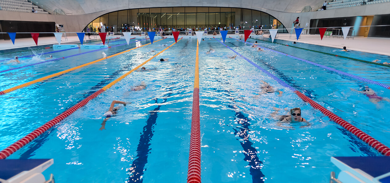 People swimming in the London Aquatics Centre pool