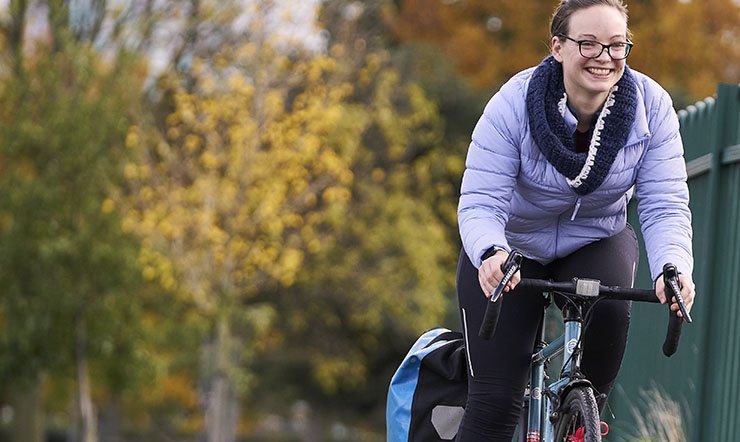 A woman rides a bike in a park.