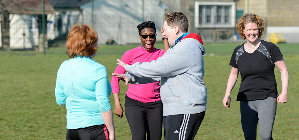 A group of women smiling as they take a break from playing rugby