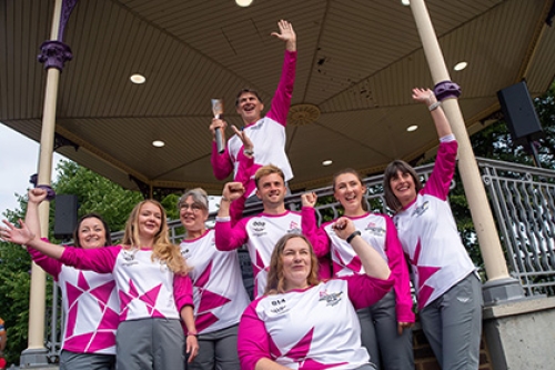 A group of Queen's Jubilee Baton Relay runners pose for a photo with the baton.