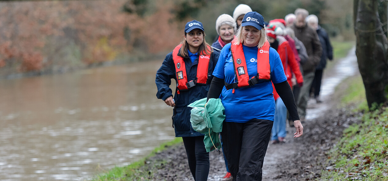 A group of people walking alongside a canal.