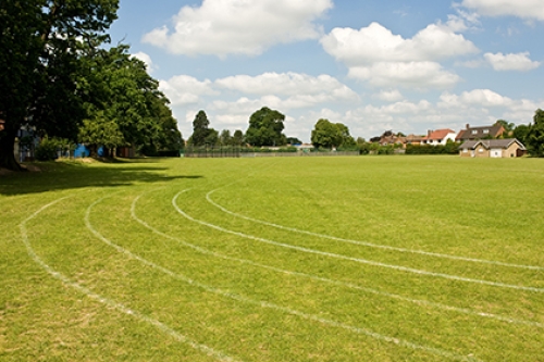 A playing field with a grass running track on it