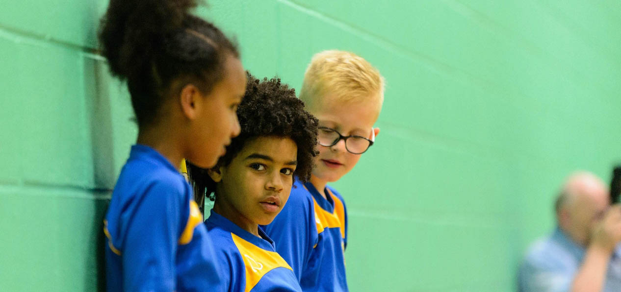 A group of children in a sports hall.