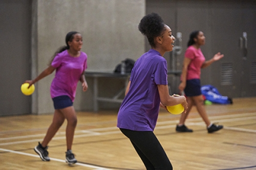 Group of young girls playing ball games in a sports hall