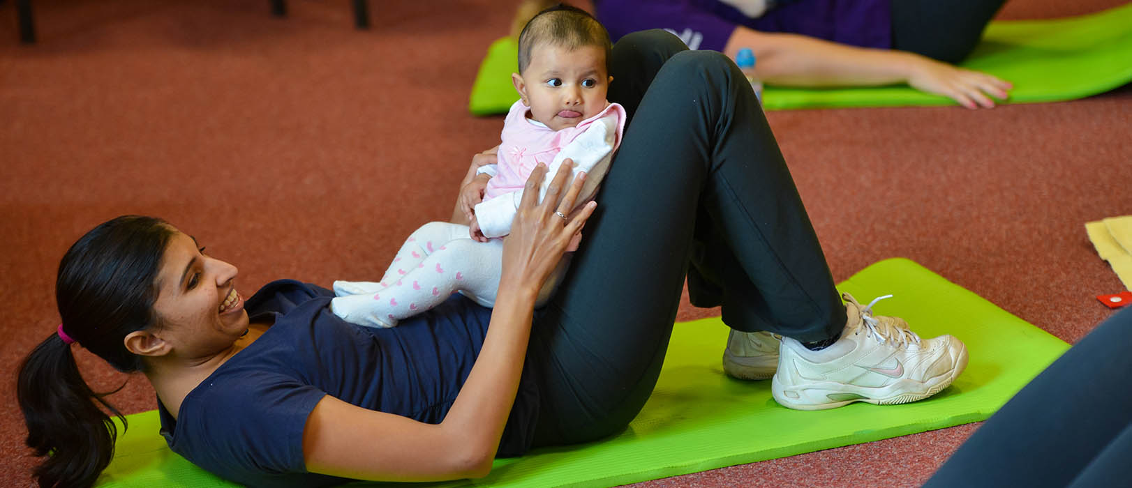 A woman does an exercise class with her baby