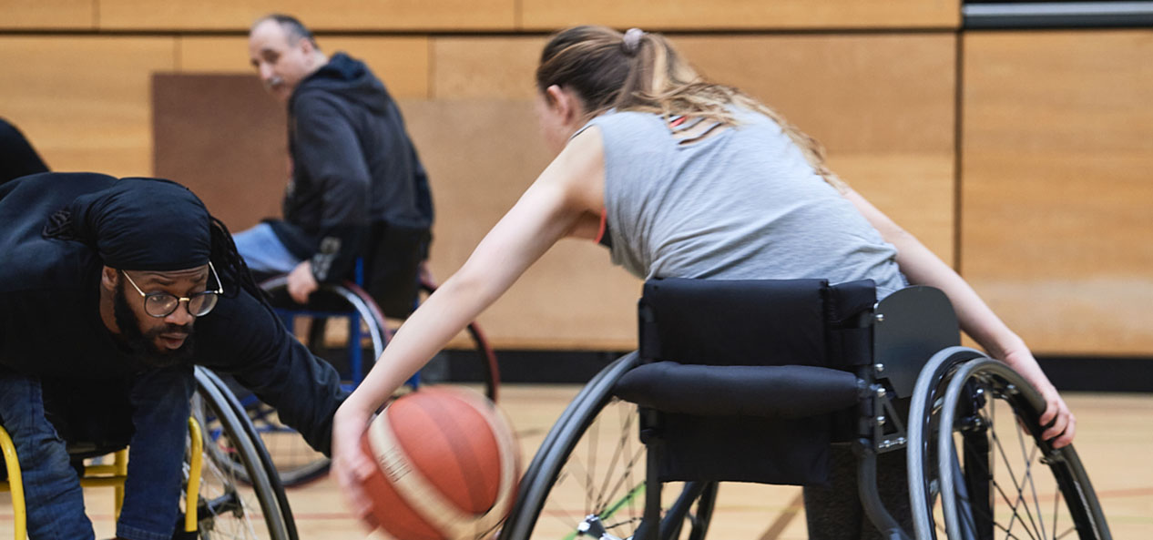 Two people playing wheelchair basketball