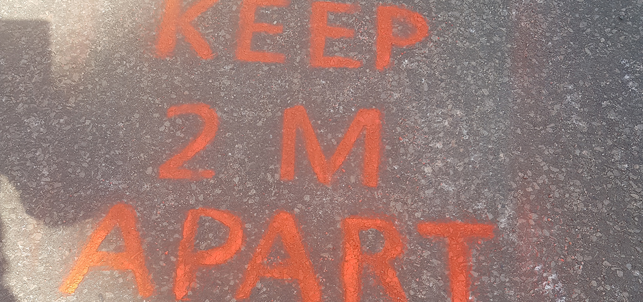 A social distancing message painted on the floor in a Rugby Borough Council park