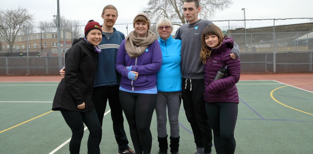 A group of young men and women from Rethink Mental Illness pose on an open-air playground. 