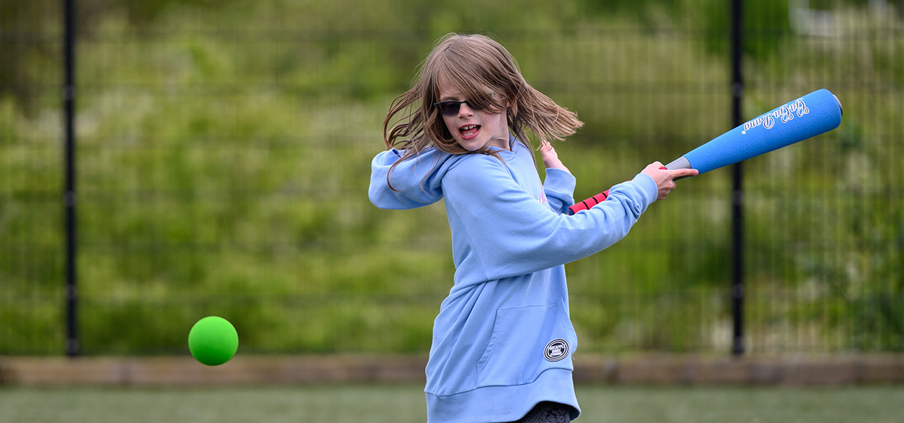 A girl playing rounders