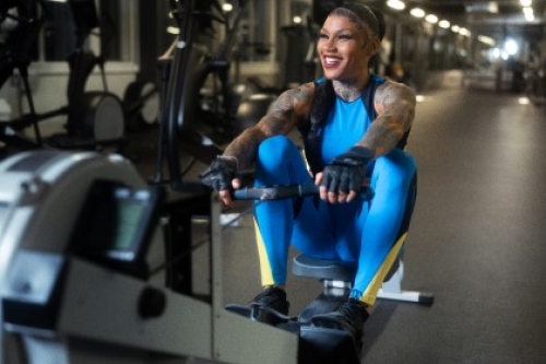 A smiling woman on a rowing machine in a gym