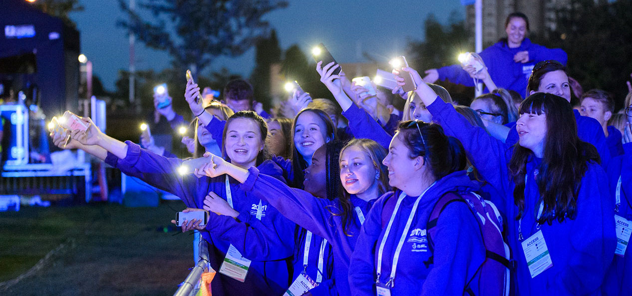 A group of schoolchildren using their phones as torches at the 2017 School Games