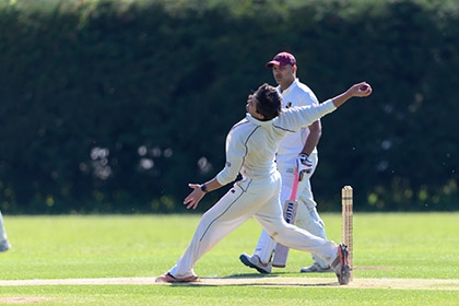 A man bowls the ball during a local league cricket match