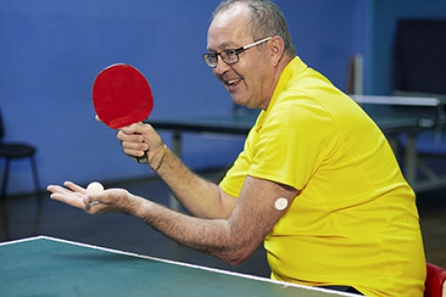 We Are Undefeatable case study Simon, plays table tennis in his wheelchair, with a blood glucose monitor patch on his arm