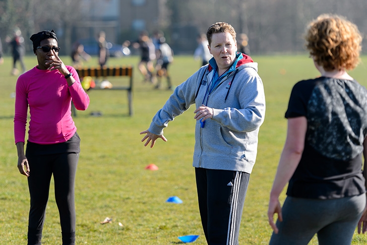 A group of volunteers talking to each other on a playing field.