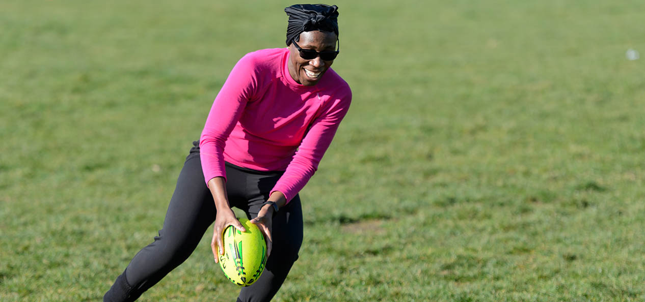 A woman playing rugby.