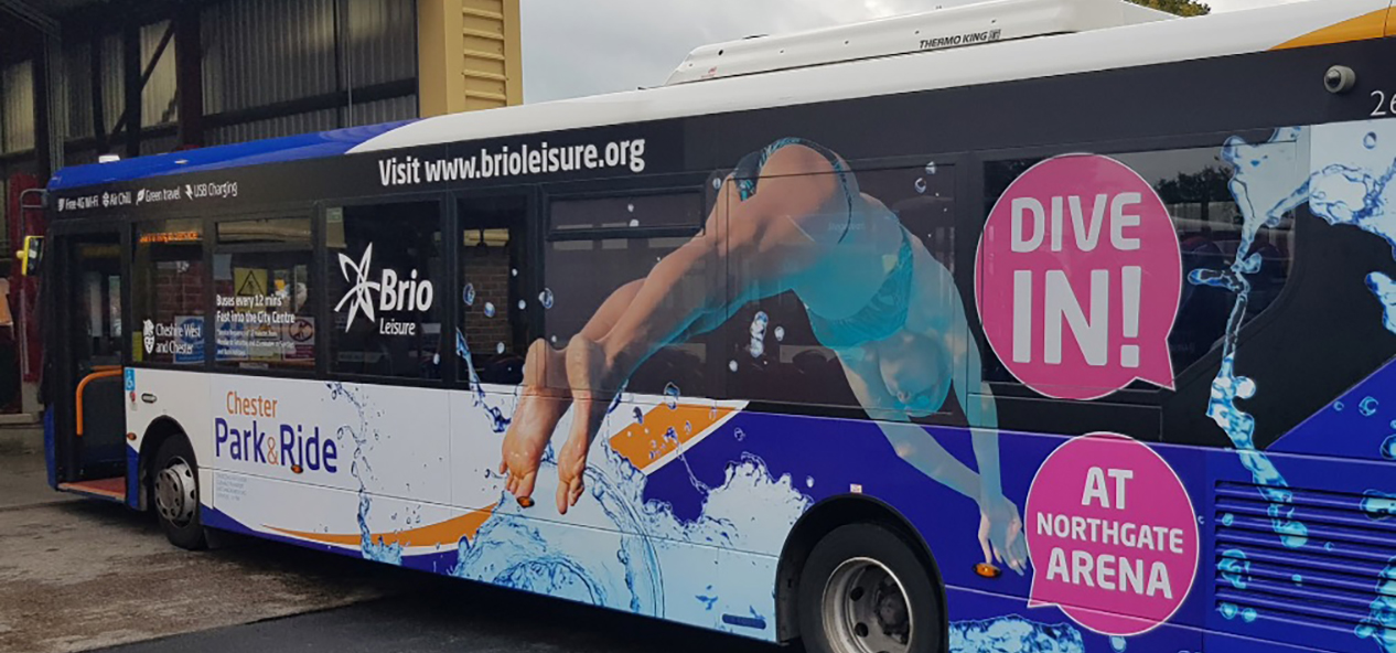 An advert for community swimming pool, on the side of a bus