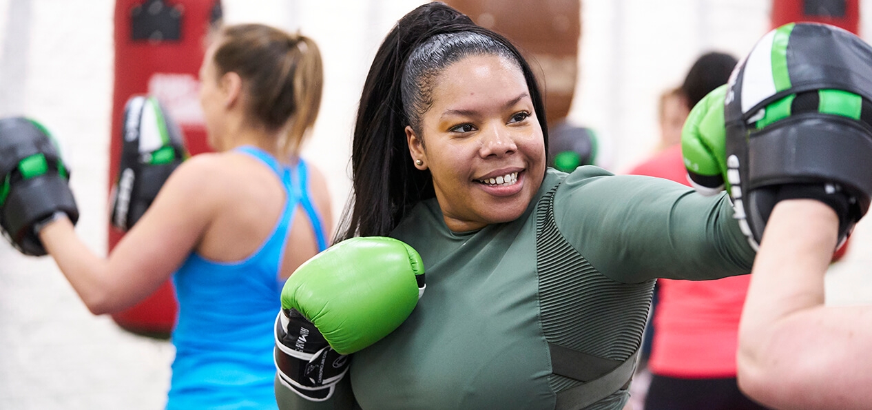 A woman practicing some boxing shots at an indoor session.