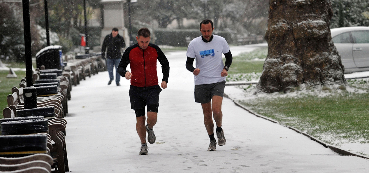 Two joggers exercise in the snow