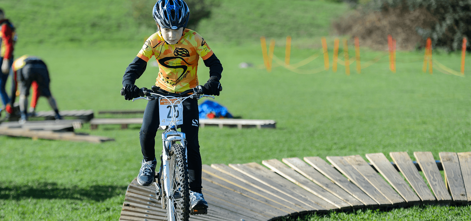 Boy riding bicycle outdoors on wooden path