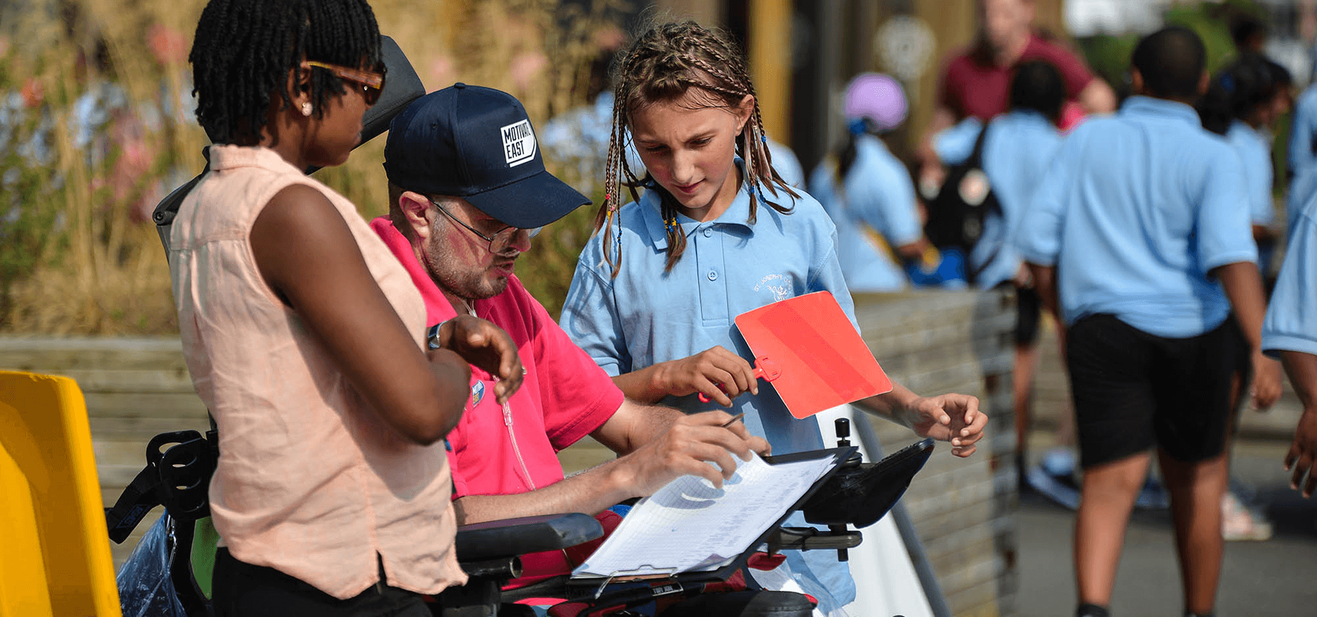 Coach in wheelchair talking to young girl