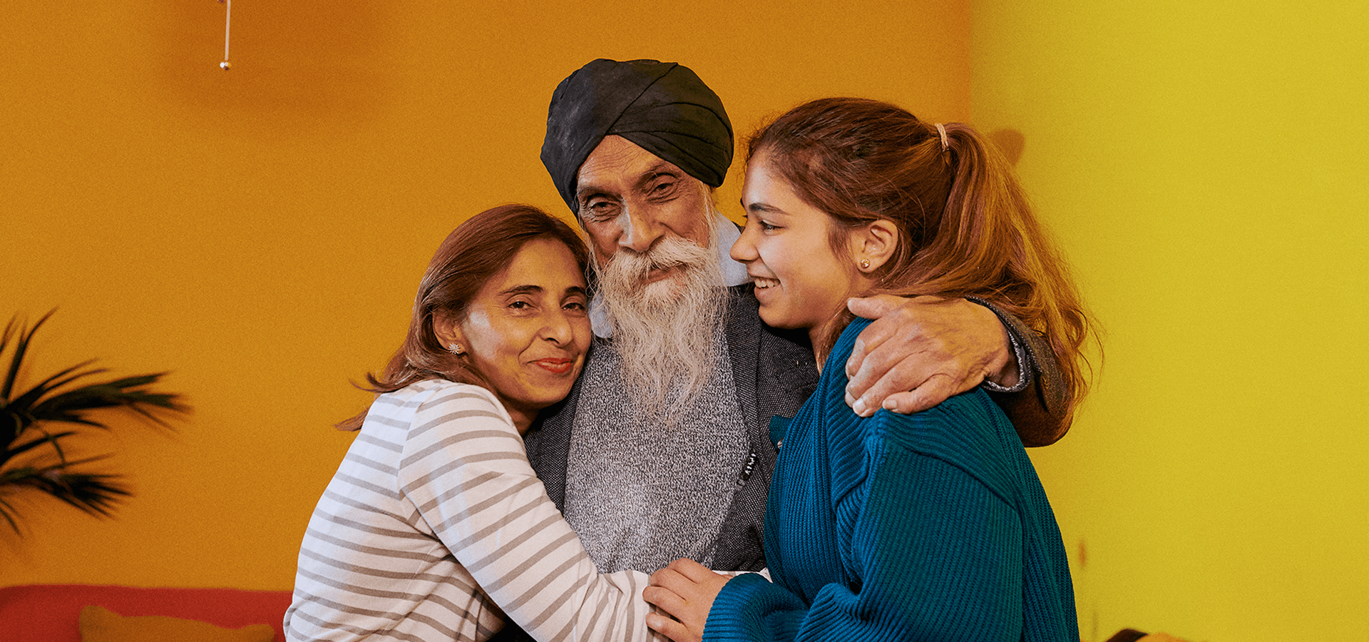 Daughter and granddaughter hugging grandfather