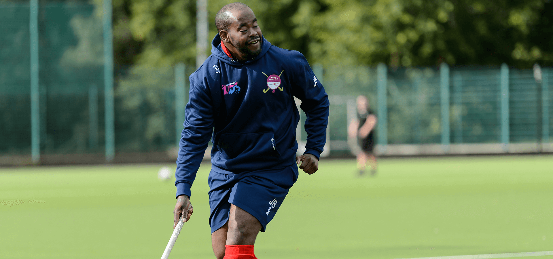 Man running on pitch playing hockey