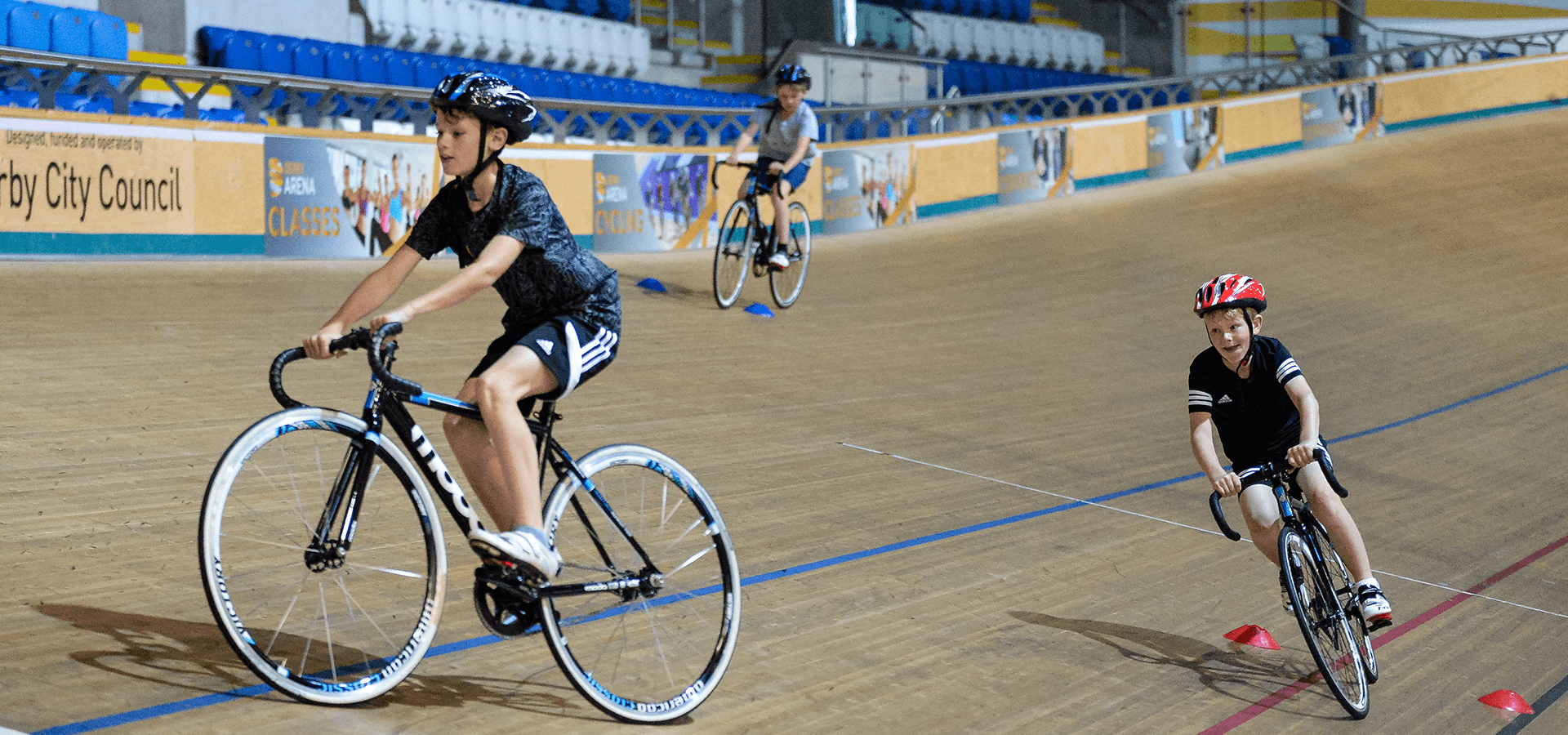 Three boys cycling on velodrome